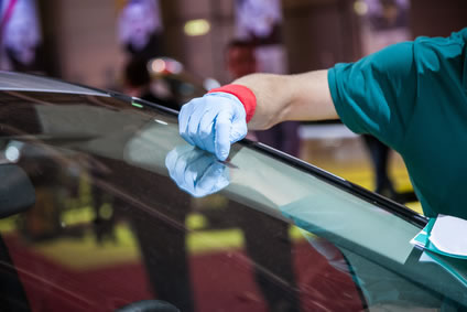 A man replacing a car windshield.